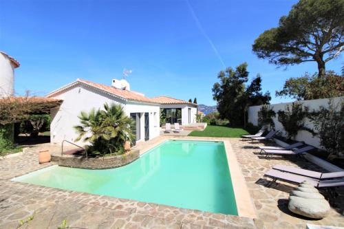 a swimming pool in front of a house at La madrague-Villa/Piscine vue Mer/Clim/Wifi in Hyères