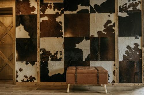 a brown suitcase sitting on a stool in front of a wall at Luxury Chalet Kajmer in Jurgów