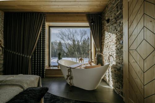 a bath tub in a room with a window at Luxury Chalet Kajmer in Jurgów