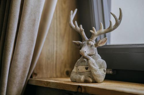 a statue of a reindeer sitting on a window sill at Luxury Chalet Kajmer in Jurgów