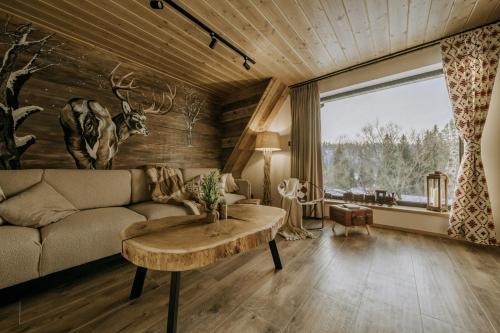 a living room with a couch and a table at Luxury Chalet Kajmer in Jurgów