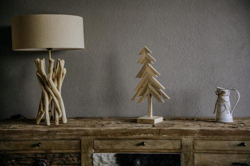 a table with a lamp and a christmas tree on it at Luxury Chalet Kajmer in Jurgów