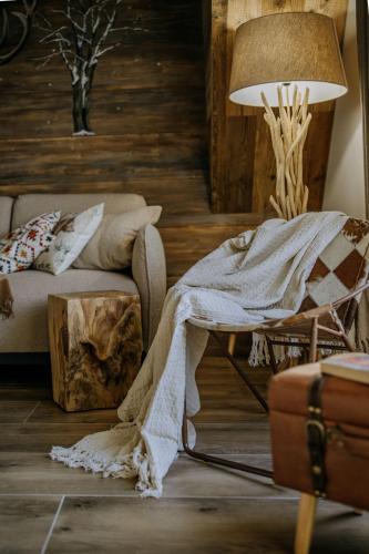 a living room with a blanket on a chair and a lamp at Luxury Chalet Kajmer in Jurgów