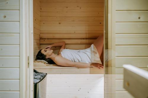a woman is laying in a sauna at Luxury Chalet Kajmer in Jurgów