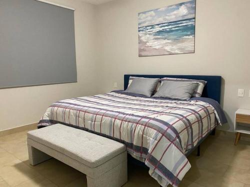 a bedroom with a bed with a bench and a painting at Beautiful apartment, Playa del Carmen, Jacuzzi in Playa del Carmen