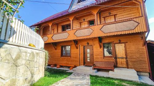 uma casa de madeira com uma cerca em frente em Котедж Біля лісу em Yaremche