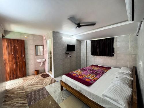 1 dormitorio con 1 cama y TV. en Royal Grand Residency, en Pondicherry