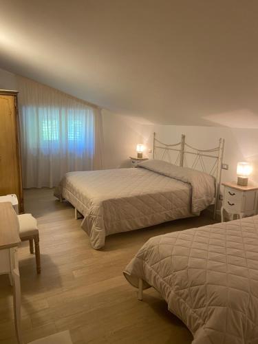 a hotel room with two beds and a window at Villacolle Visso in Visso