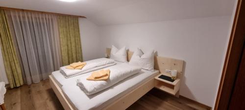 a bedroom with a bed with white sheets and pillows at Ferienwohnung Marlin in Sankt Gallenkirch