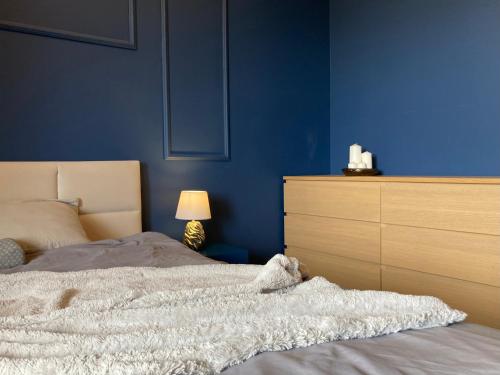 niebieska sypialnia z łóżkiem i komodą w obiekcie Gold Apart w Poznaniu