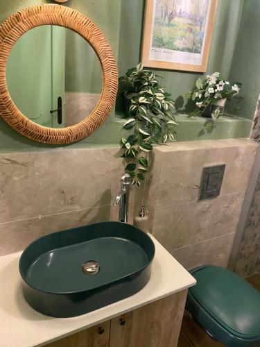 a bathroom with a green sink and a mirror at HOUSE KA TEKKE 2 in Çanakkale