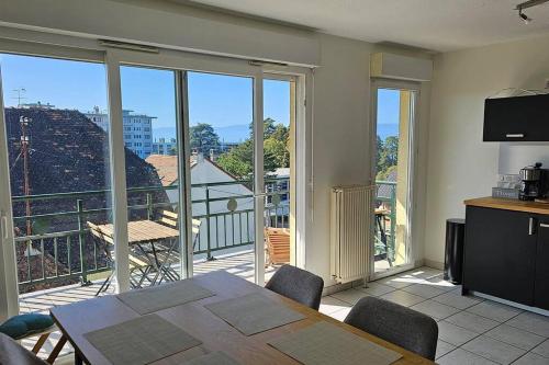 ein Esszimmer mit einem Tisch und Blick auf einen Balkon in der Unterkunft Le Clos Fleury in Thonon-les-Bains