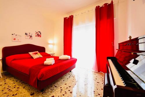 a bedroom with a red bed and a piano at Floral Holiday in Minori