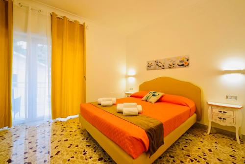 a bedroom with a bed with orange sheets and a window at Floral Holiday in Minori