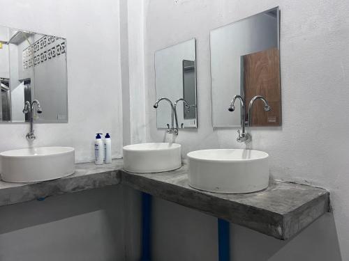 two sinks in a public bathroom with two mirrors at Say My Name in Koh Phangan