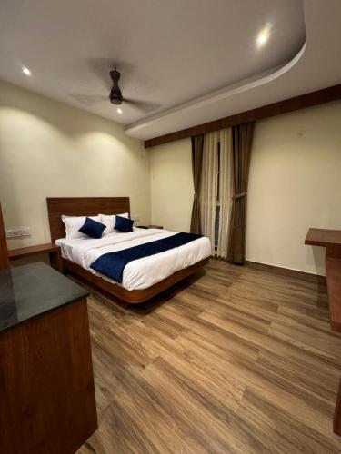 a bedroom with a bed with blue pillows on it at S K Legacy Hotel in Mysore