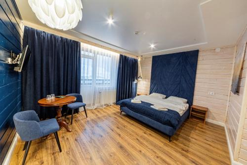 - une chambre avec un lit, une table et des chaises dans l'établissement Готель Поляницький, à Bukovel