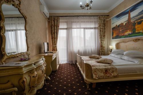 Schlafzimmer mit einem Bett, einem Spiegel und einem Schreibtisch in der Unterkunft Hotel Royal in Râmnicu Vâlcea