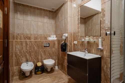 ein Bad mit einem Waschbecken und einem WC in der Unterkunft Hotel Royal in Râmnicu Vâlcea