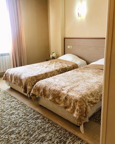 a bedroom with two beds and a window at Elena Hotel in Petrich