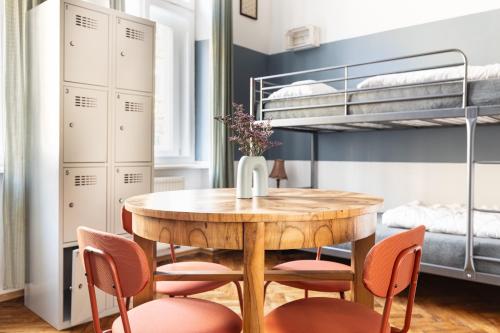 a dining room with a table and chairs and bunk beds at Das Hostel in Krakow