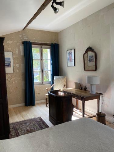 Saint-Martin-le-BeauにあるMoulin de Battereau - Jardin & Verger - 9km d'Amboiseのデスク、椅子、窓が備わる客室です。