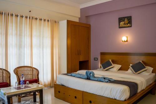 a bedroom with a bed with a blue blanket on it at White House Residency in Varkala