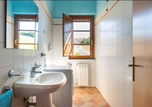 y baño con lavabo y espejo. en Terra di Mezzo en Volterra