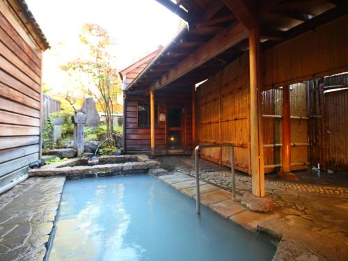 a pool of water outside of a house at Ryokan Sakaya in Nozawa Onsen