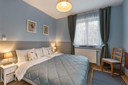 Un dormitorio con una cama grande y una ventana en Apartamenty Tyrol en Szczawnica