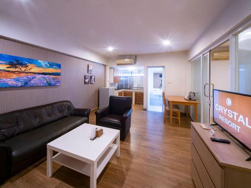 a living room with a couch and a tv at Crystal Resort Korat in Nakhon Ratchasima