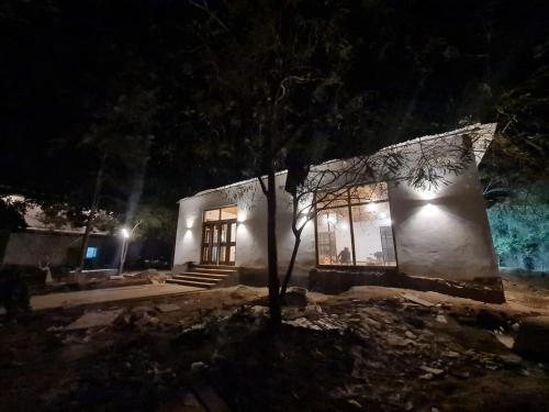 una casa por la noche con un árbol delante de ella en Bamera house, en Tāla