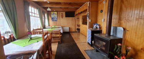 um quarto com uma cozinha com uma mesa e um fogão em Hostal Beagle em Puerto Williams