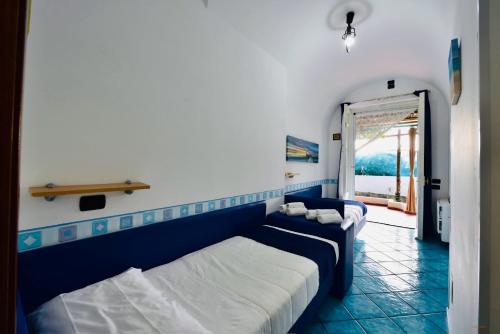 a bedroom with two beds and a door to a balcony at Eden Holiday in Minori