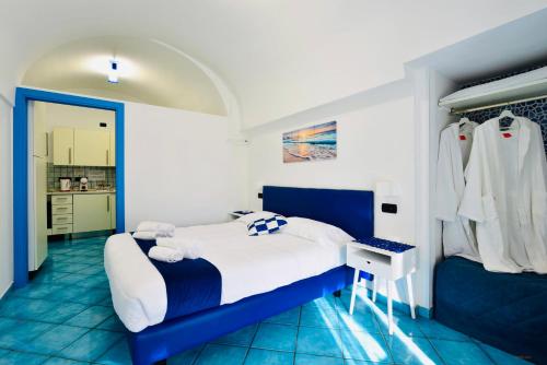 a blue and white bedroom with a bed and a desk at Eden Holiday in Minori