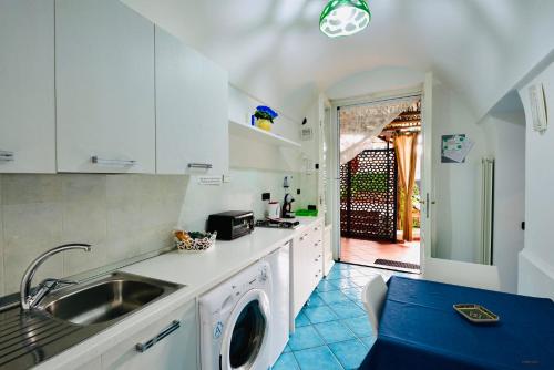 a kitchen with a sink and a washing machine at Eden Holiday in Minori