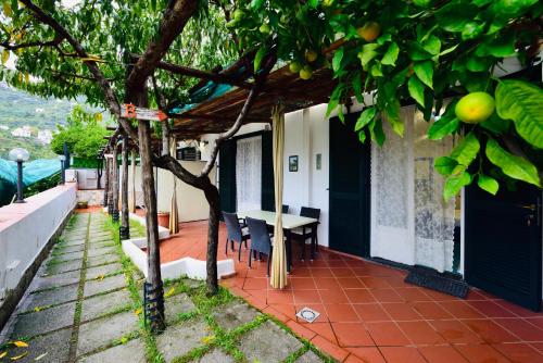 a house with a table and chairs under a tree at Eden Holiday in Minori