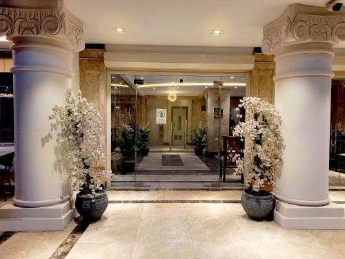 a lobby with columns and flowers in pots at Jasmine Inn Deluxe in Badr