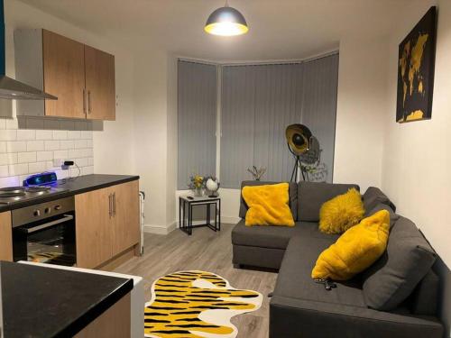 sala de estar con sofá gris y almohadas amarillas en Apartment Near Leeds City Centre Sleeps 4, en Beeston Hill