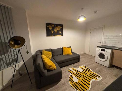 a living room with a couch and a microwave at Apartment Near Leeds City Centre Sleeps 4 in Beeston Hill