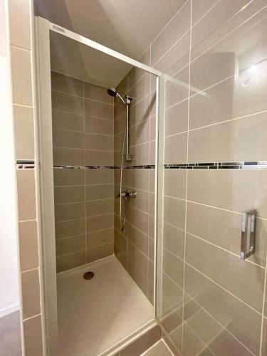 y baño con ducha y puerta de cristal. en Charming appartement with a view of the Saone, en Mâcon
