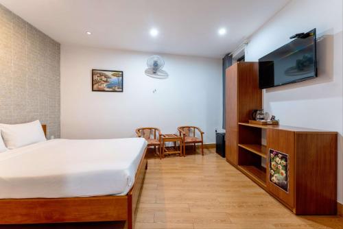 a hotel room with a bed and a flat screen tv at Cucumber Hostel in Hoi An