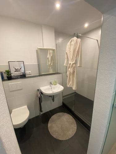 a bathroom with a sink and a toilet and a shower at Ferienwohnungen Allgäu Zimmer in Memmingen