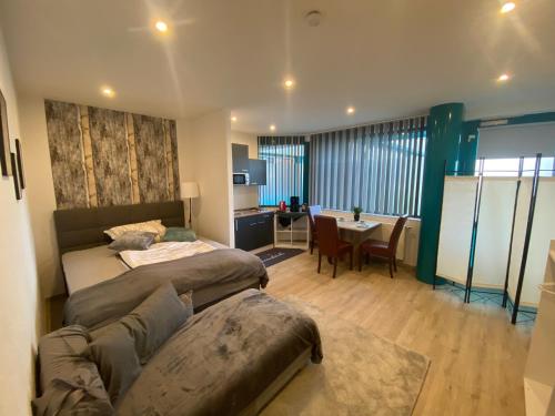 a bedroom with two beds and a table in a room at Ferienwohnungen Allgäu Zimmer in Memmingen