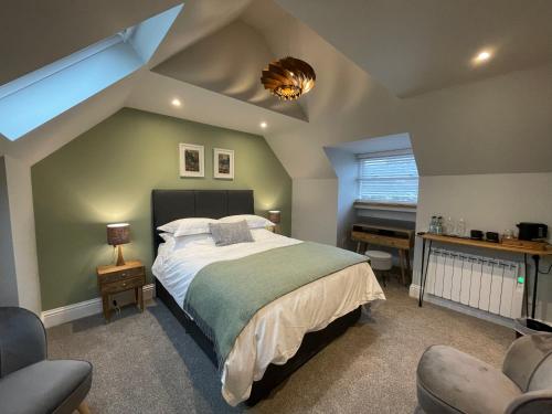 a bedroom with a bed and a desk and a piano at Allium in Tenby