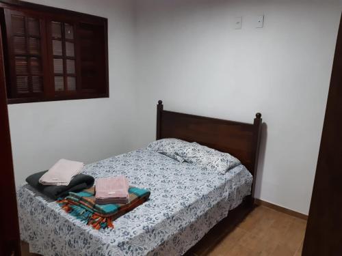 a bedroom with a bed with a wooden head board at Casa Cantinho da Roça Recanto Lobo Guará in Gonçalves