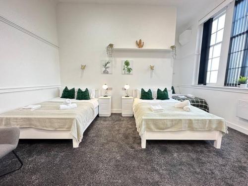 a room with two beds with green pillows at Modern Spacious Flat in Dudley Area in Birmingham