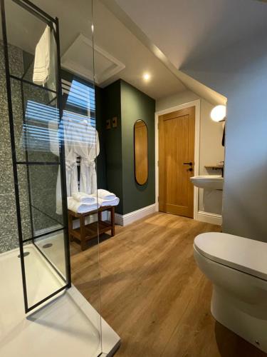 a bathroom with a toilet and a glass case at Allium in Tenby