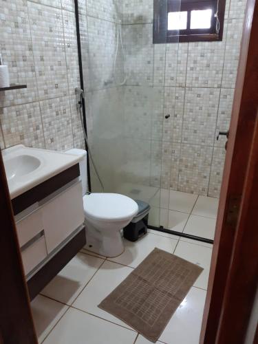uma casa de banho com um WC, um chuveiro e um lavatório. em Casa Cantinho da Roça Recanto Lobo Guará em Gonçalves