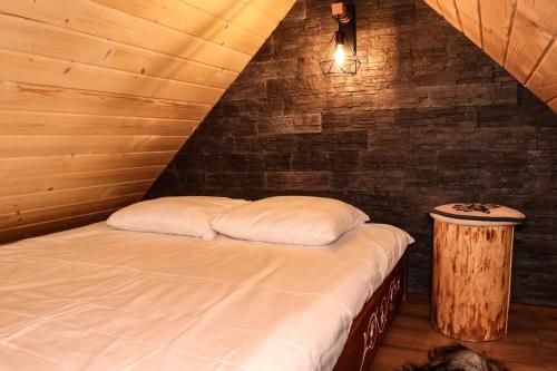 a bed with two pillows in a room at Domek Parzenica Nowy Targ in Nowy Targ